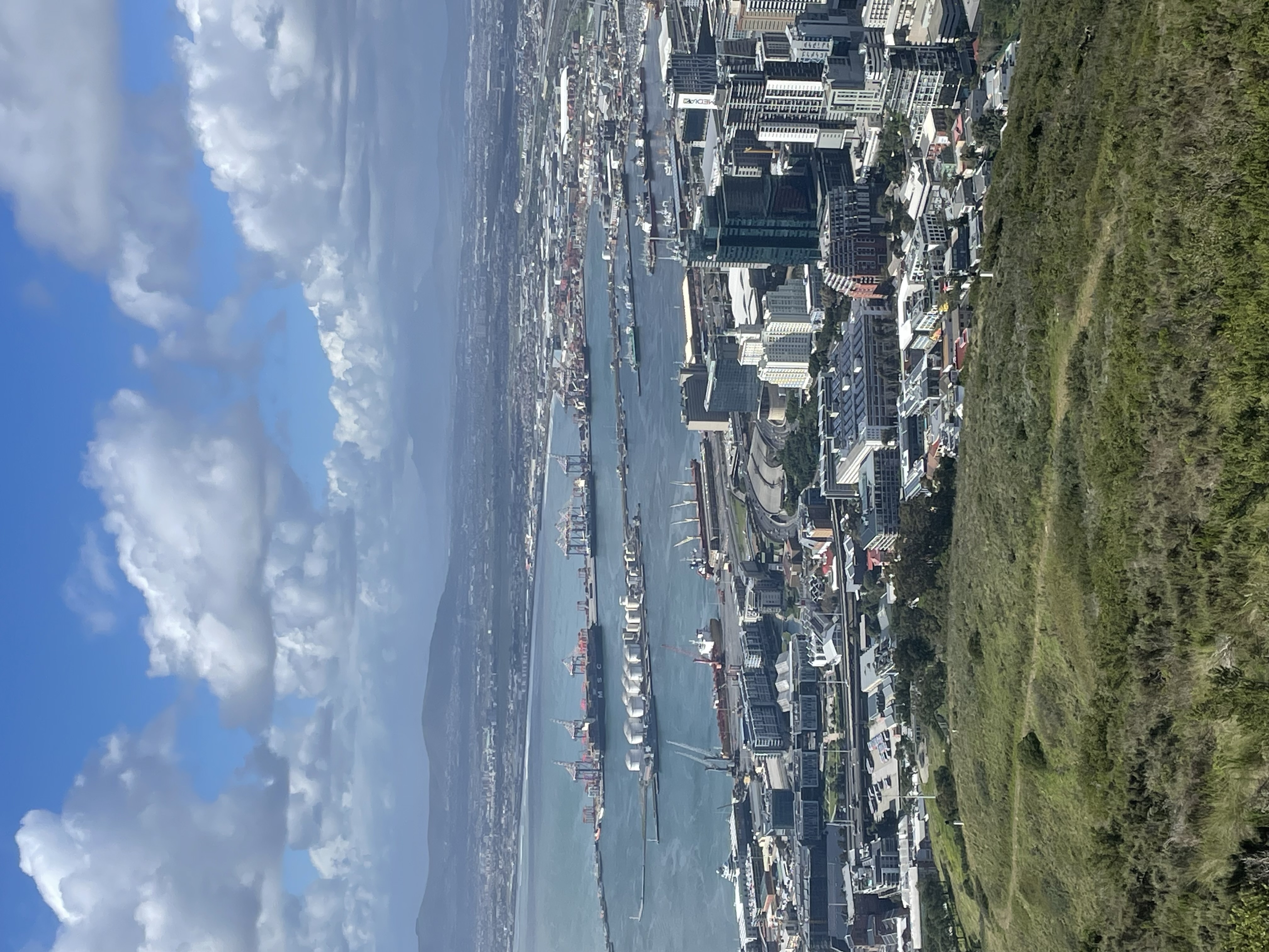 Aerial view of Cape Town's harbor with container ships, Table Mountain visible across the bay