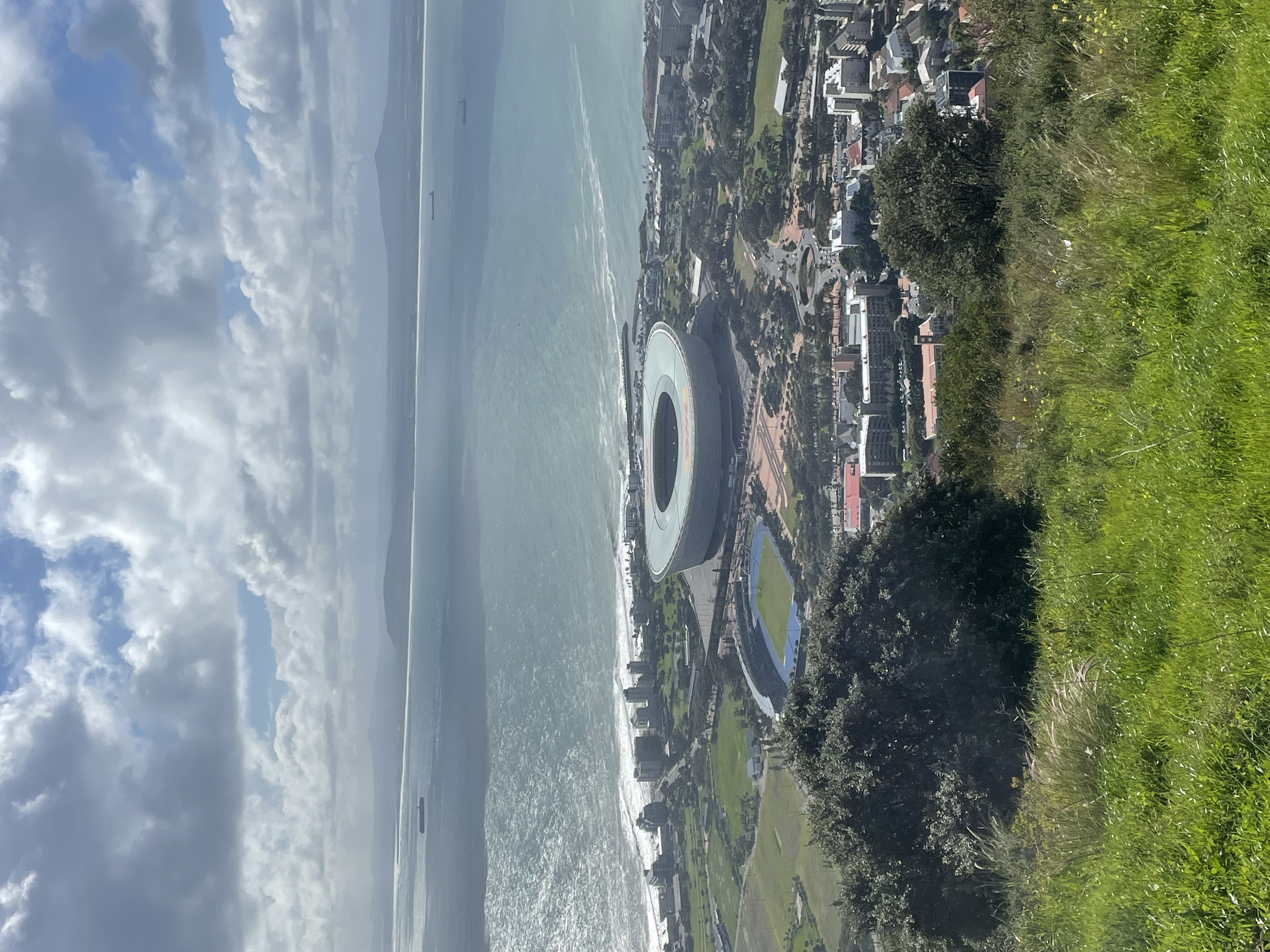 Aerial view of Cape Town's stadium and coastline with mountains and ocean in background