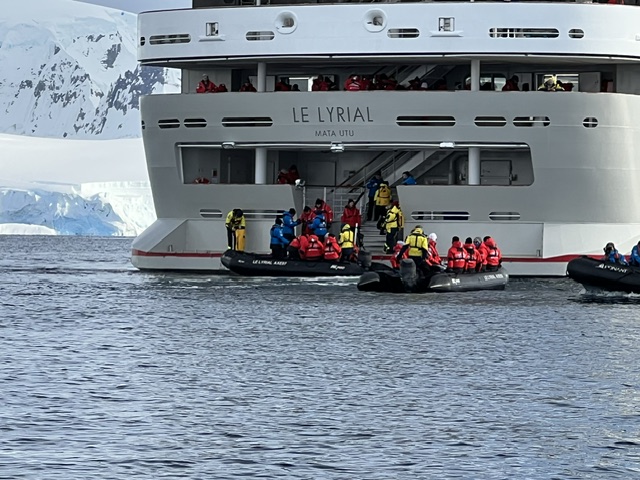 Passengers in red life jackets board zodiacs from the expedition ship Le Lyrial in Antarctic waters
