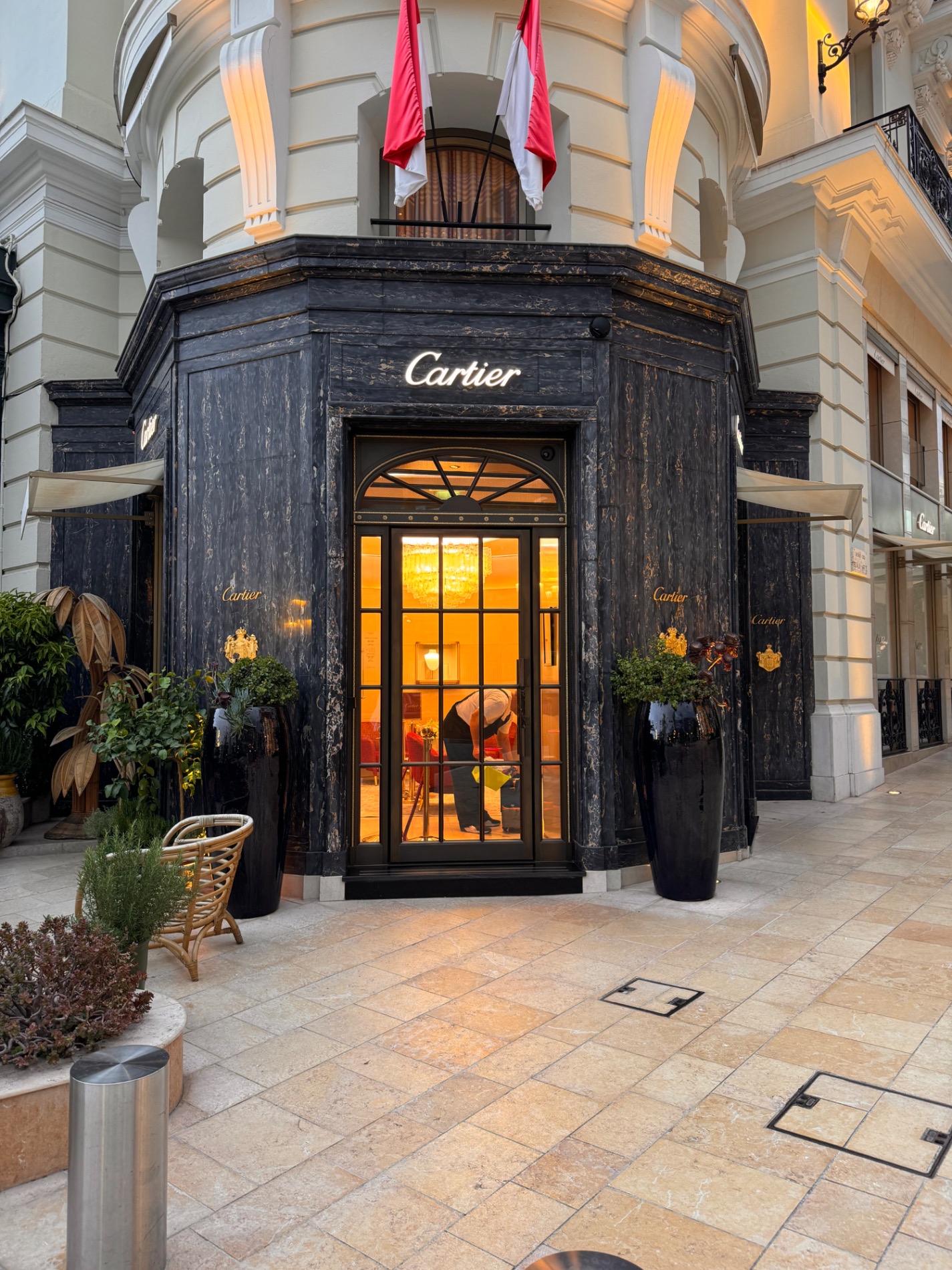 Cartier luxury boutique storefront with black wooden facade and glowing windows on elegant shopping street