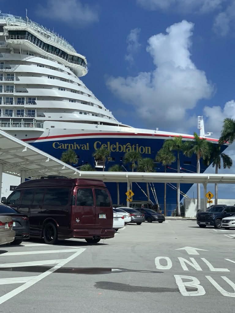 Carnival Celebration cruise ship docked at port with palm trees and clear blue sky
