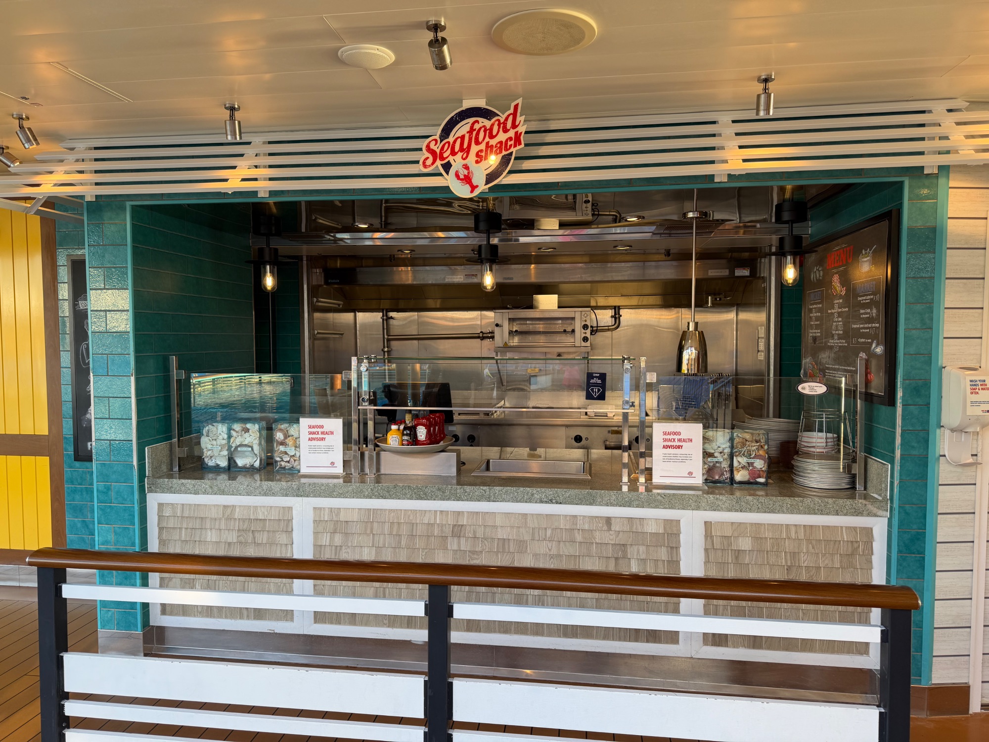 Seafood Shack restaurant counter on ship with teal tile accents and menu board