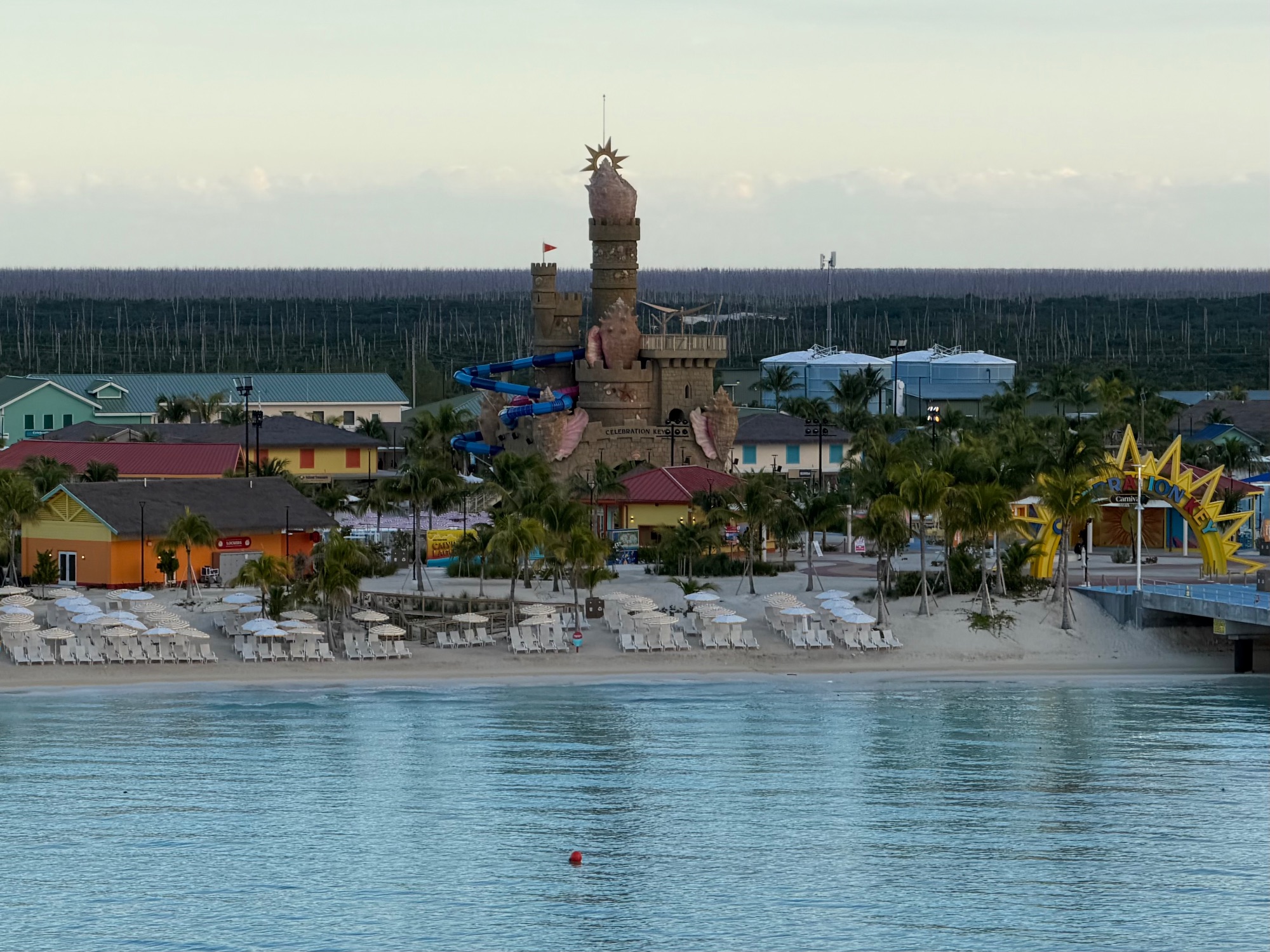 Aerial view of Celebration Key beach resort with castle structure and white loungers