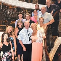 Group photo of multiple people posing together indoors at what appears to be a formal event or gathering