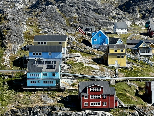 Hillside settlement of Greenland with brightly painted houses in blue, red, and yellow stacked on rocky slopes