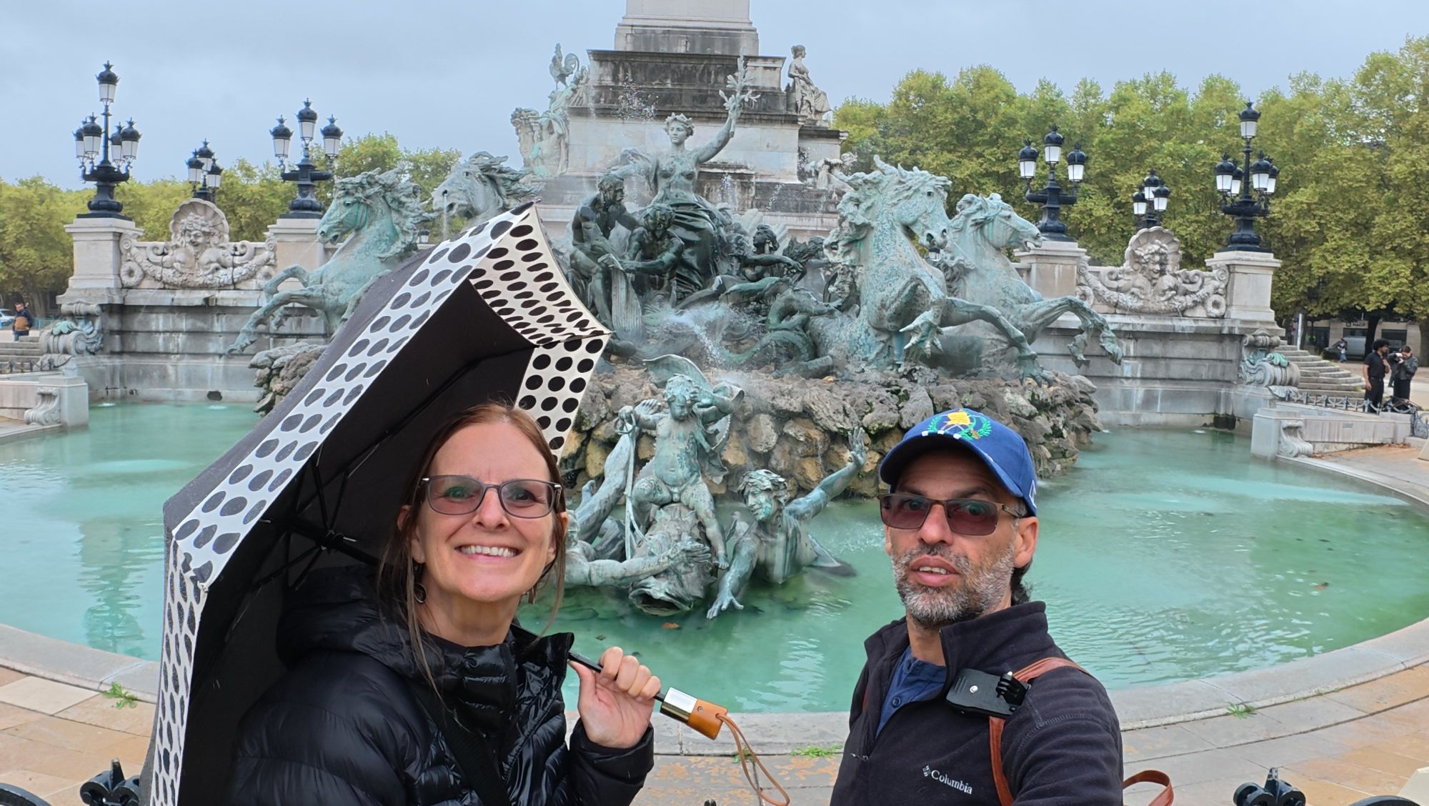Victoria and companion posing at the Fontaine de la Concorde in Paris with turquoise water behind
