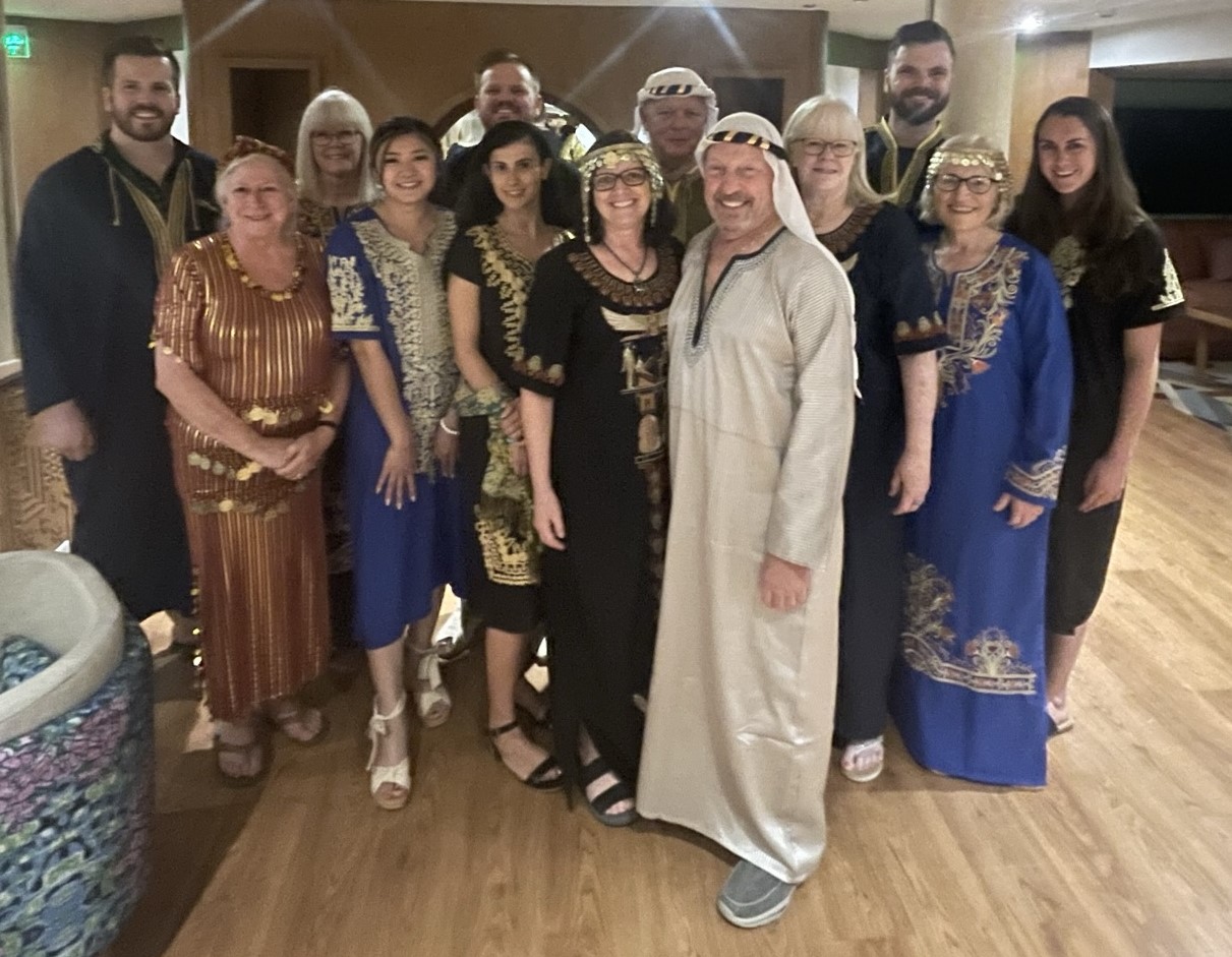 Group of people dressed in Egyptian-themed costumes at an indoor evening gathering